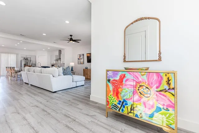 a view of a patio with couches table and chairs and potted plants with wooden floor and fence