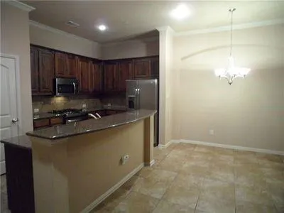 a kitchen with stainless steel appliances granite countertop a sink a stove and a refrigerator