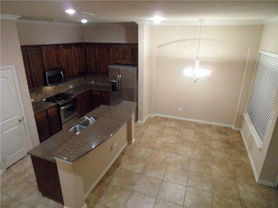 5321 Locust Drive McKinney, TX 75070 - Photo 7 of 17 a kitchen with granite countertop a refrigerator and a stove top oven