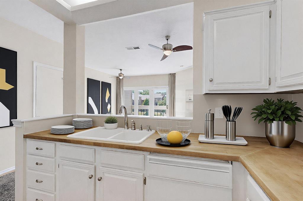 14277 Preston Road, Unit 923 Dallas, TX 75254 - Photo 18 of 39 a kitchen with a sink a potted plant and cabinets