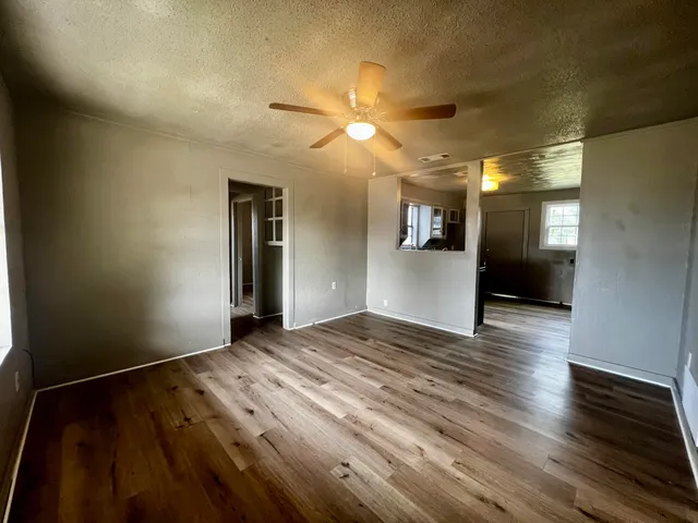 a view of empty room with wooden floor