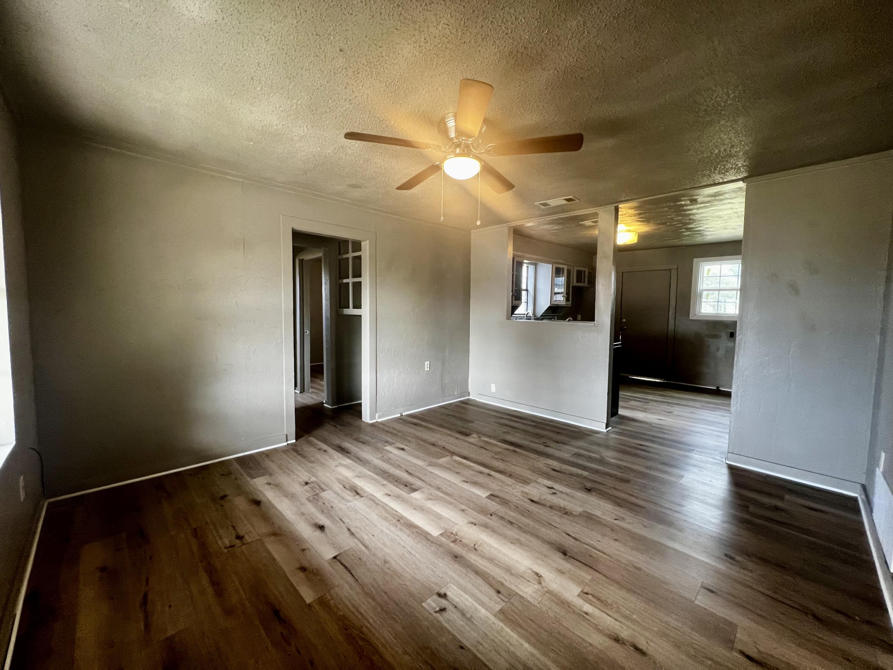220 North 6th Street Slaton, TX 79364 - Photo 2 of 8 a view of empty room with wooden floor