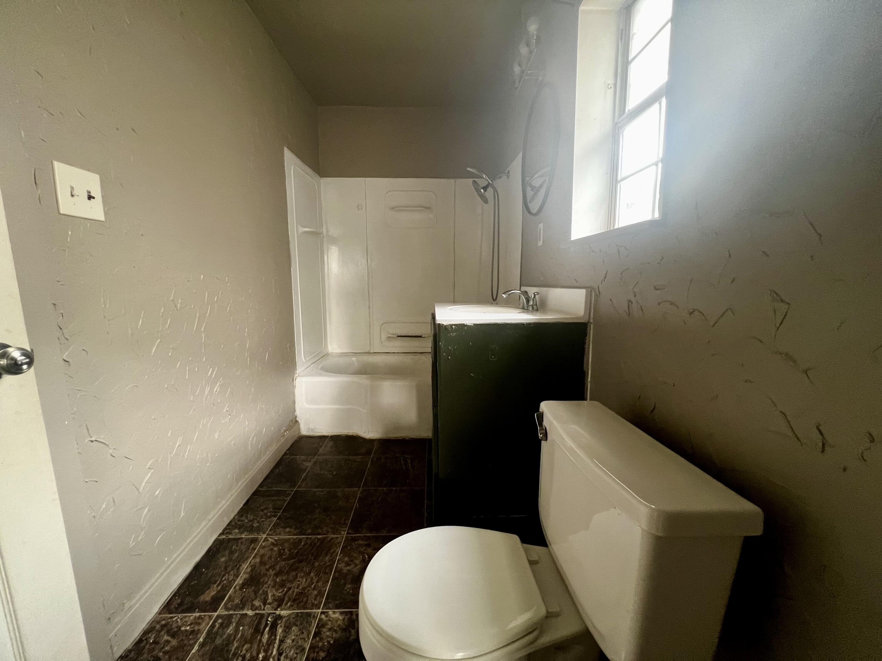 220 North 6th Street Slaton, TX 79364 - Photo 4 of 8 a bathroom with a toilet and a shower curtain