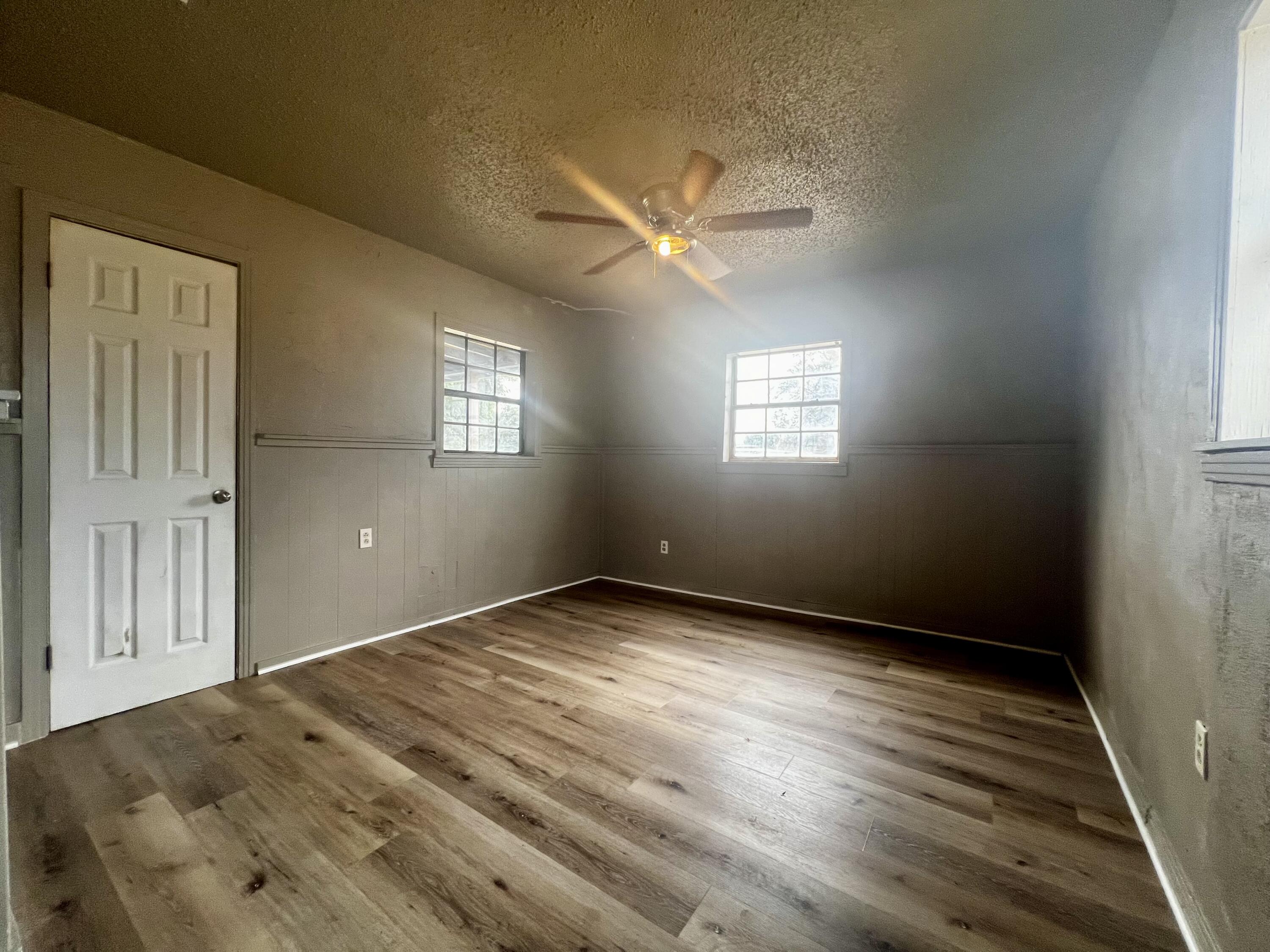 220 North 6th Street Slaton, TX 79364 - Photo 8 of 8 en empty room with windows and ceiling fan