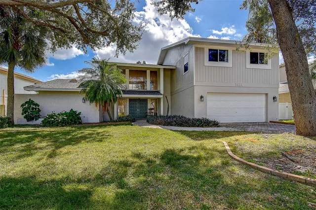 a view of a house with a yard and palm tree
