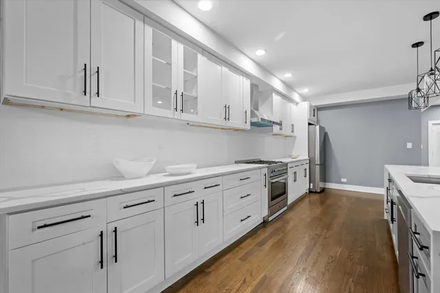 a kitchen with granite countertop white cabinets and white appliances