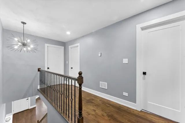 a view of a hallway with a chandelier fan and windows