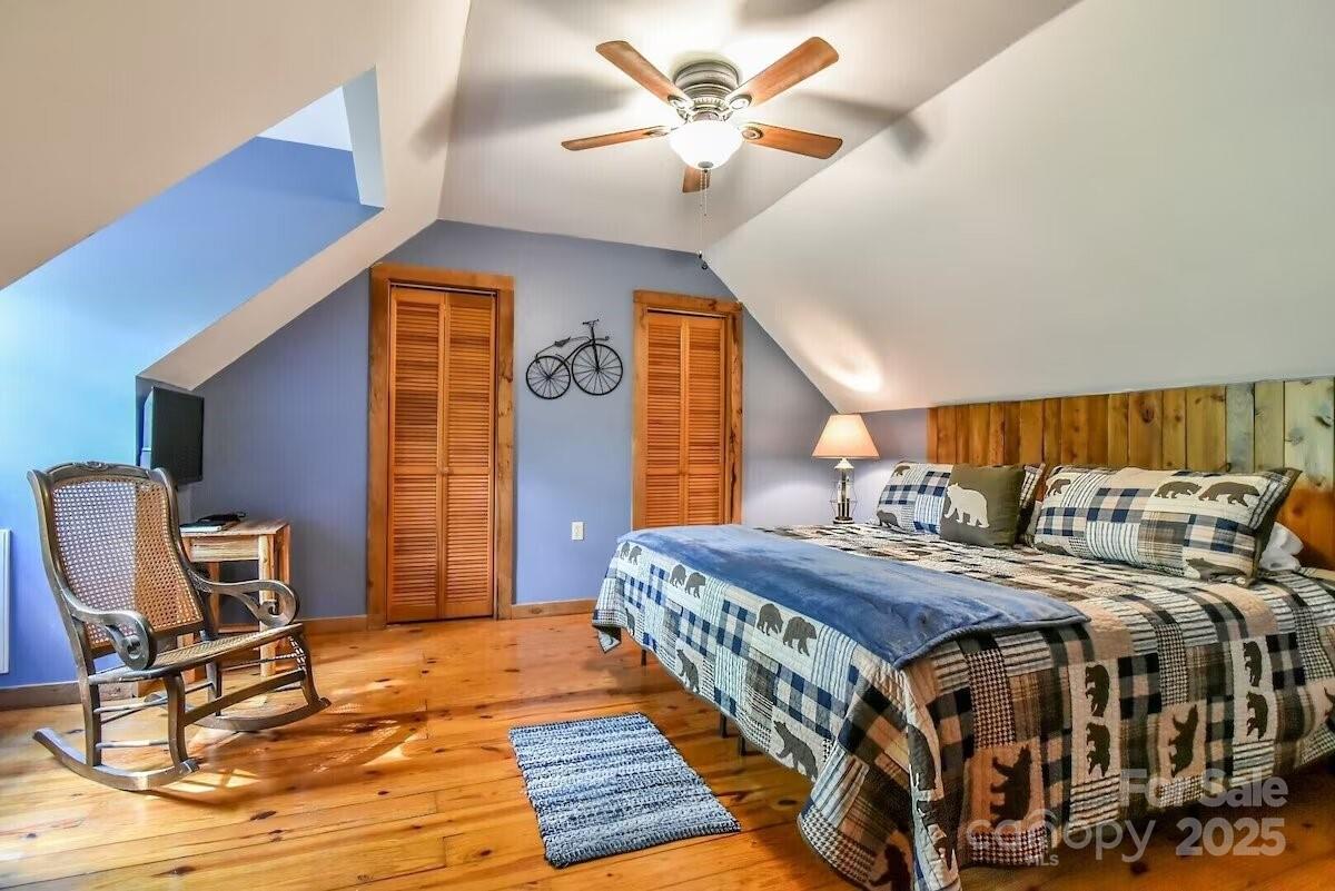 48 Buck Ridge Road Fairview, NC 28730 - Photo 16 of 38 a bedroom with a bed a rug and a chandelier