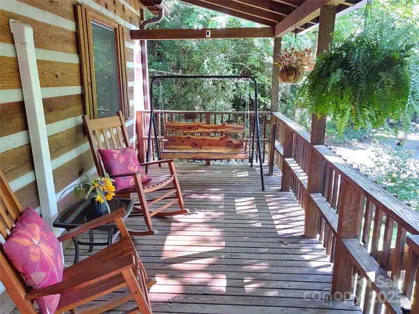 a balcony with wooden floor and outdoor seating