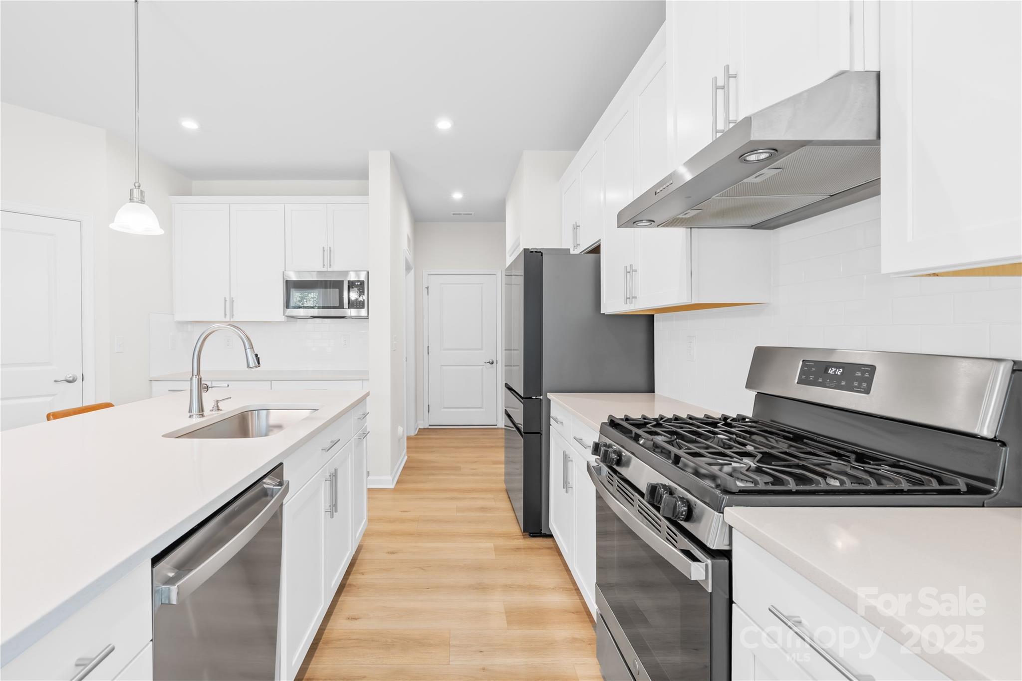3110 Streamside Drive Davidson, NC 28036 - Photo 12 of 39 a kitchen with stainless steel appliances a sink stove and cabinets
