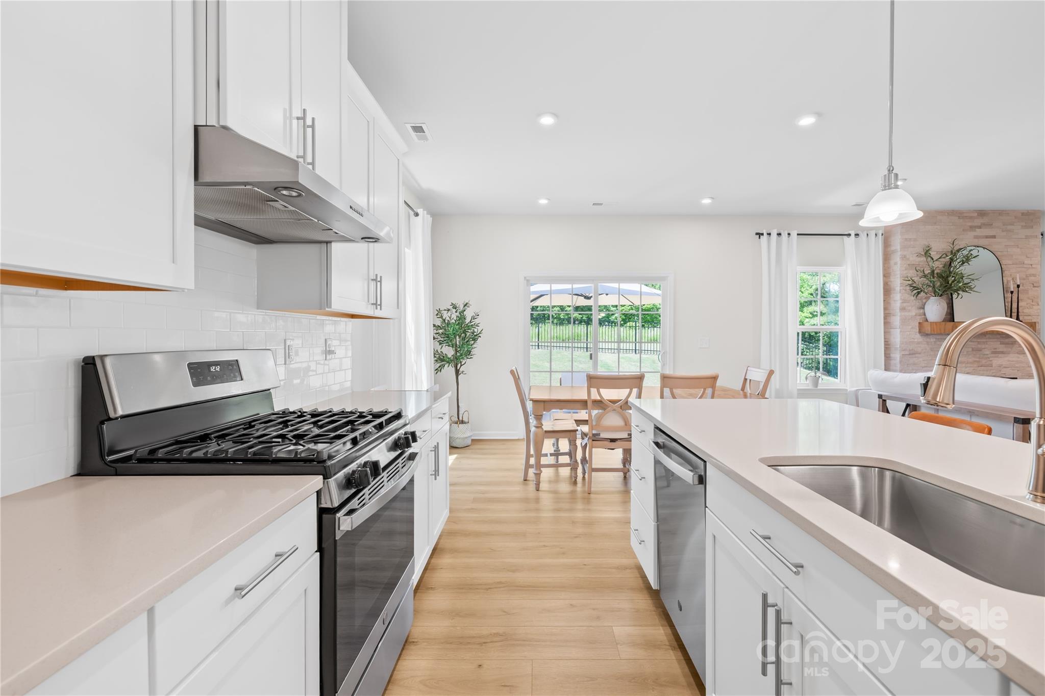 3110 Streamside Drive Davidson, NC 28036 - Photo 13 of 39 a kitchen with granite countertop a stove a sink a refrigerator and windows