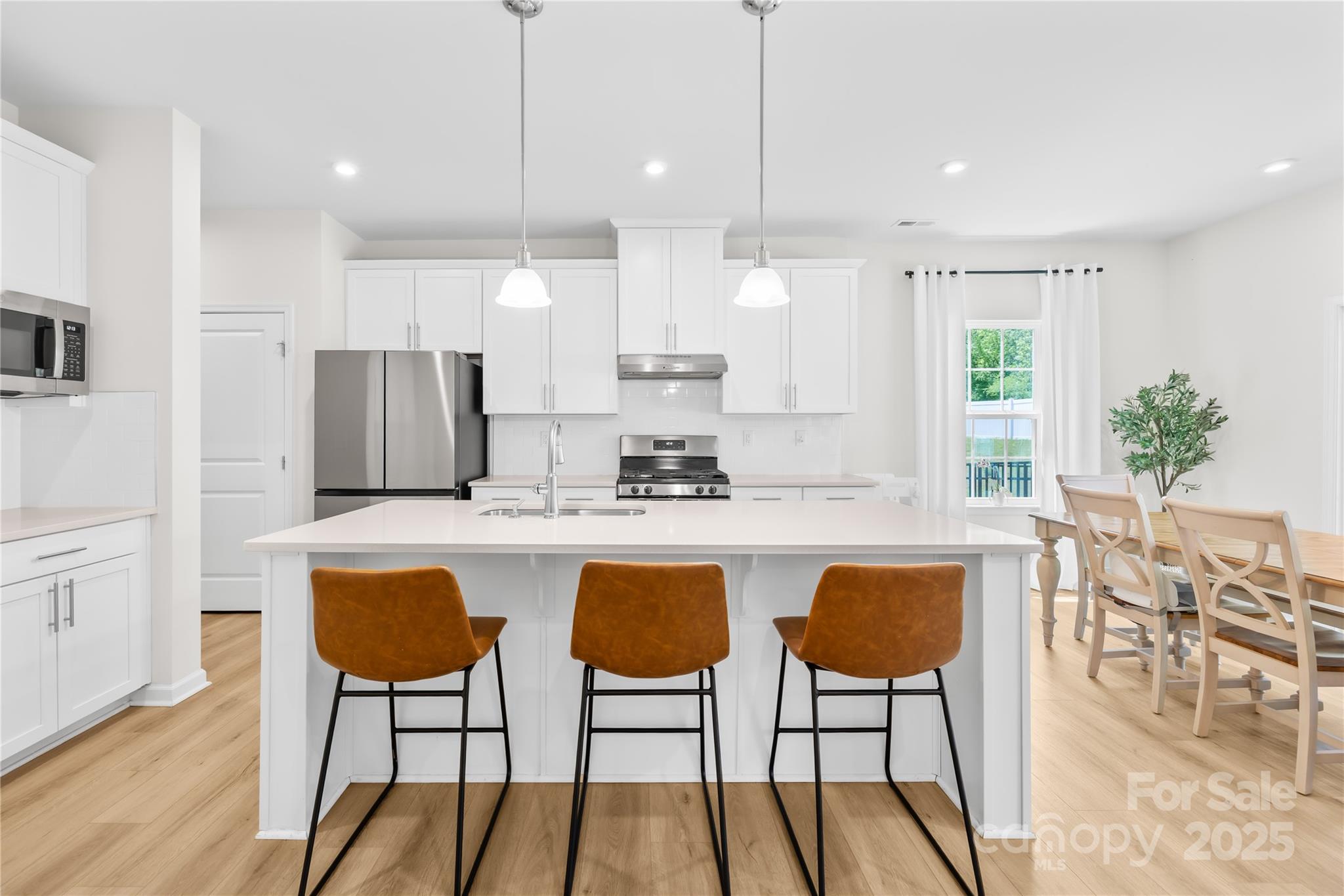 3110 Streamside Drive Davidson, NC 28036 - Photo 9 of 39 a kitchen with stainless steel appliances granite countertop table chairs refrigerator and microwave