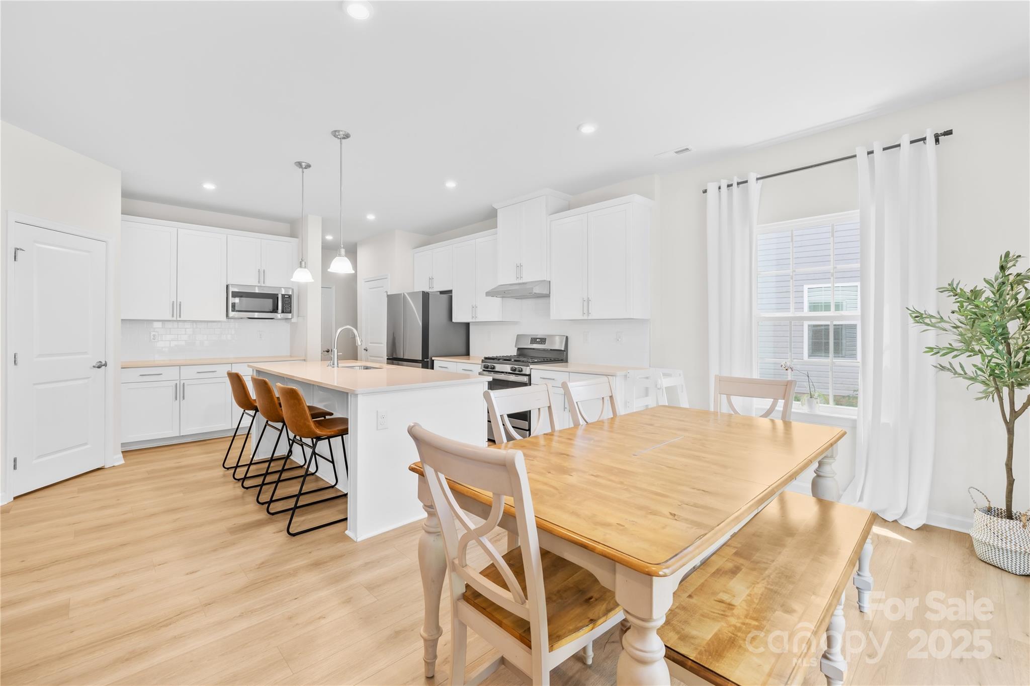 3110 Streamside Drive Davidson, NC 28036 - Photo 10 of 39 a kitchen with stainless steel appliances kitchen island granite countertop a dining table chairs and white refrigerator