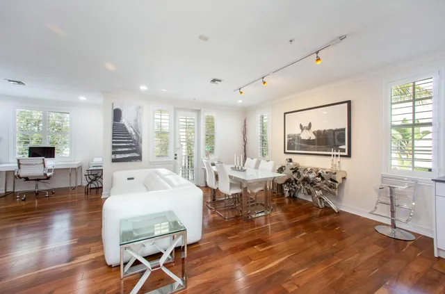 a living room with furniture a large window and wooden floor