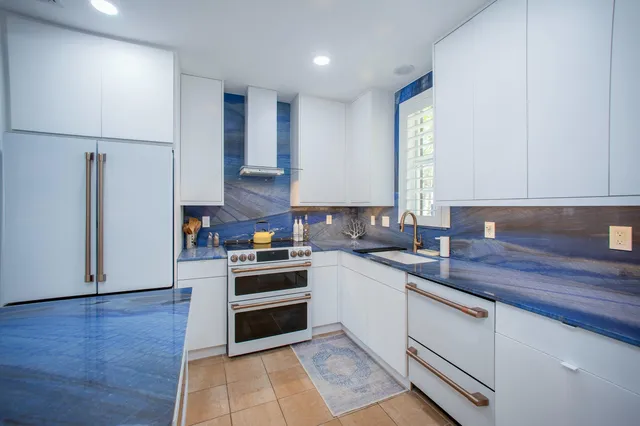 a kitchen with a sink cabinets stainless steel appliances and a window