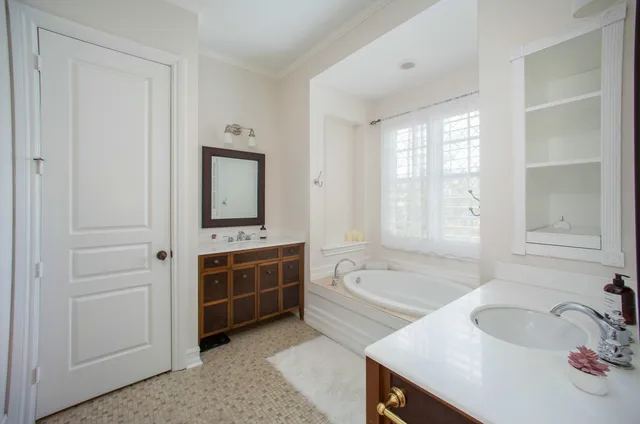 a bathroom with a tub sink and mirror
