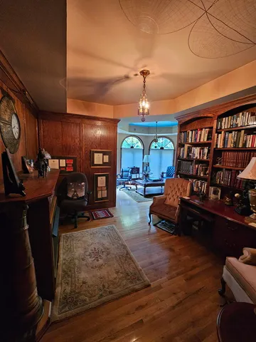 a living room with furniture gym equipment and a chandelier