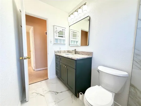 a bathroom with a toilet sink and mirror
