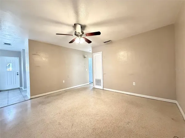 an empty room with closet and a chandelier fan