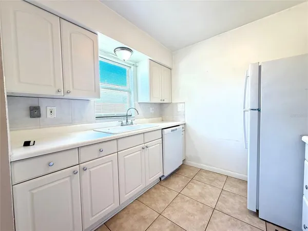 a kitchen with white cabinets and a refrigerator