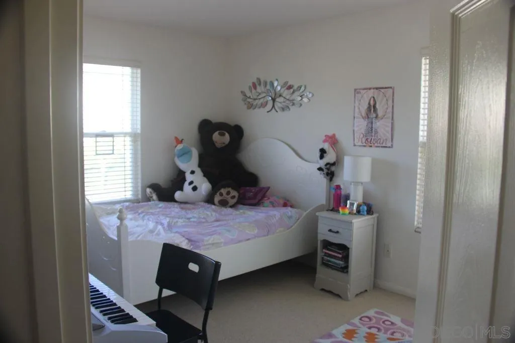 1467 Beechtree Road San Marcos, CA 92078 - Photo 2 of 8 a bedroom with a bed and a chandelier