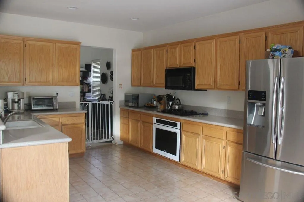 1467 Beechtree Road San Marcos, CA 92078 - Photo 8 of 8 a kitchen with stainless steel appliances granite countertop a refrigerator stove top oven a sink and dishwasher