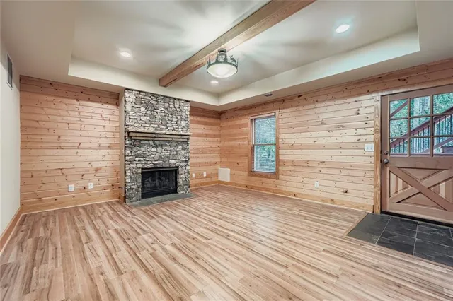a view of empty room with wooden floor and fireplace