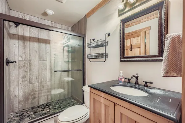 a bathroom with a granite countertop sink toilet and shower