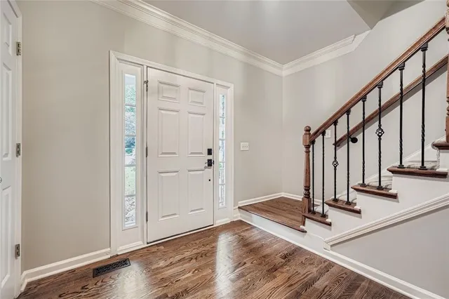 a view of a hallway with wooden floor and staircase