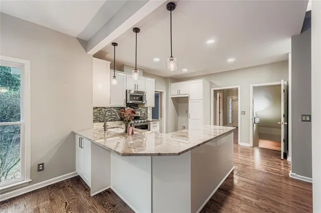a large kitchen with kitchen island a sink stainless steel appliances and a center island