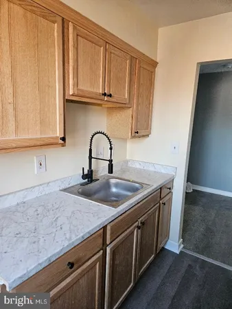 a kitchen with granite countertop a refrigerator and a sink