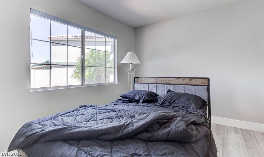 1 Rising Sun Court Henderson, NV 89074 - Photo 16 of 47 A well-lit bedroom features a large window offering neighborhood views and durable flooring.