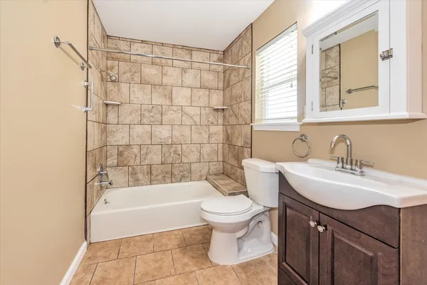 a bathroom with a sink toilet a mirror and bathtub