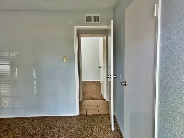 a view of an empty room with a fireplace and a window