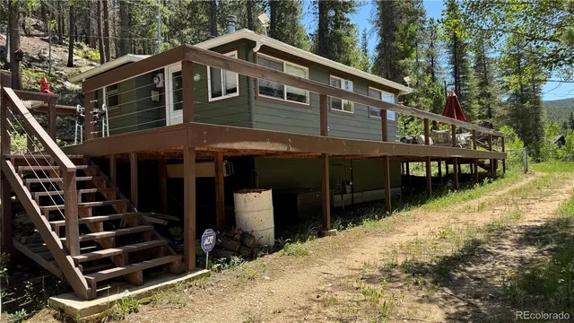 a backyard of a house with barbeque oven and trees