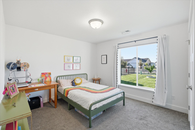 1422 West 3410th Street South Logan, UT 84321 - Photo 18 of 33 Carpeted room featuring a large window with white trim, a flush-mount ceiling light, and white interior walls