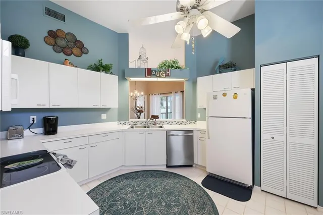 a kitchen with a refrigerator a sink cabinets and wooden floor