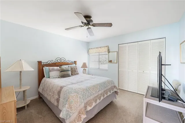a bedroom with a bed and a flat tv screen on the dresser
