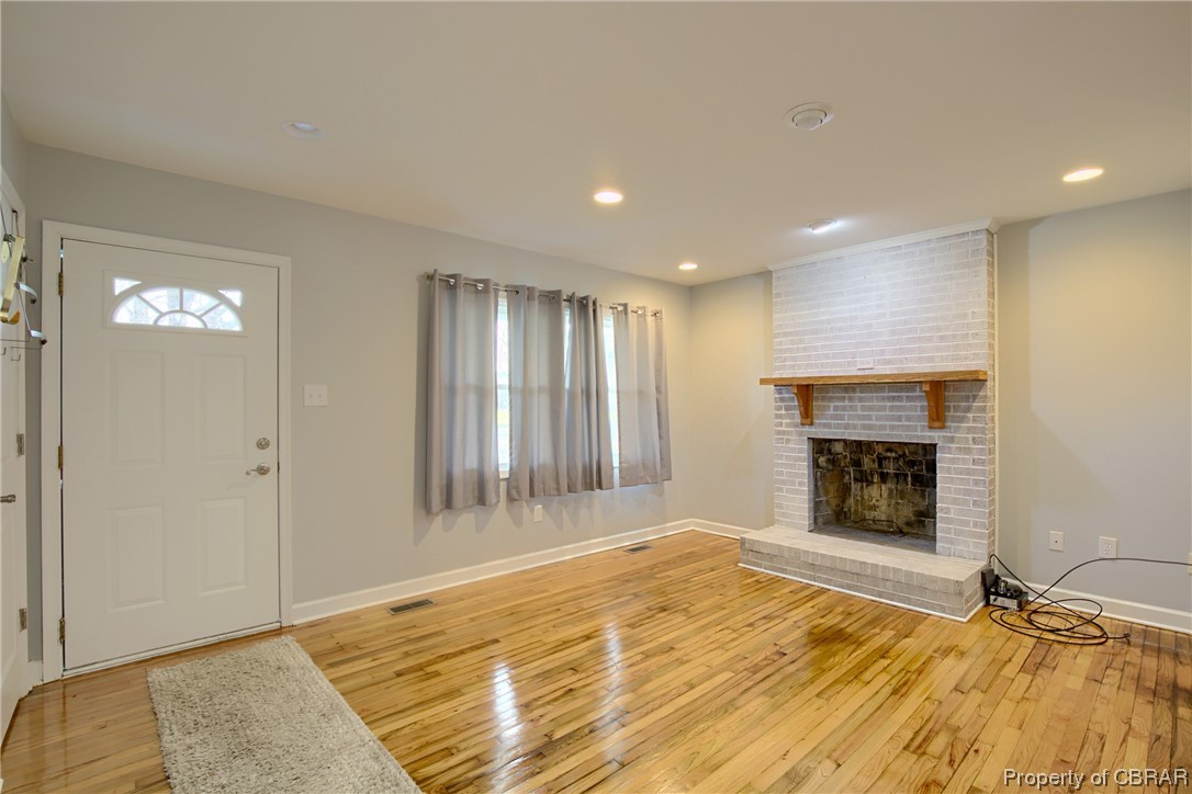 1373 Fitchetts Wharf Road Moon, VA 23119 - Photo 5 of 22 Foyer entrance featuring light hardwood / wood-style flooring, a fireplace, and brick wall