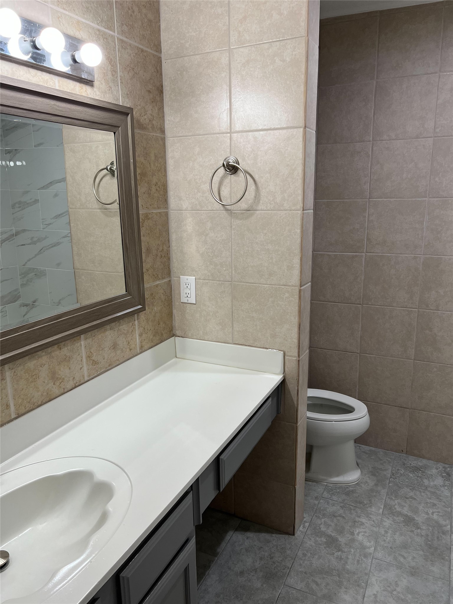 711 Pigeon Forge Road Pflugerville, TX 78660 - Photo 6 of 9 Bathroom with toilet, tile patterned flooring, vanity, and tile walls