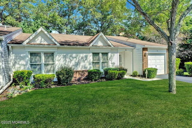 a front view of a house with a yard and potted plants