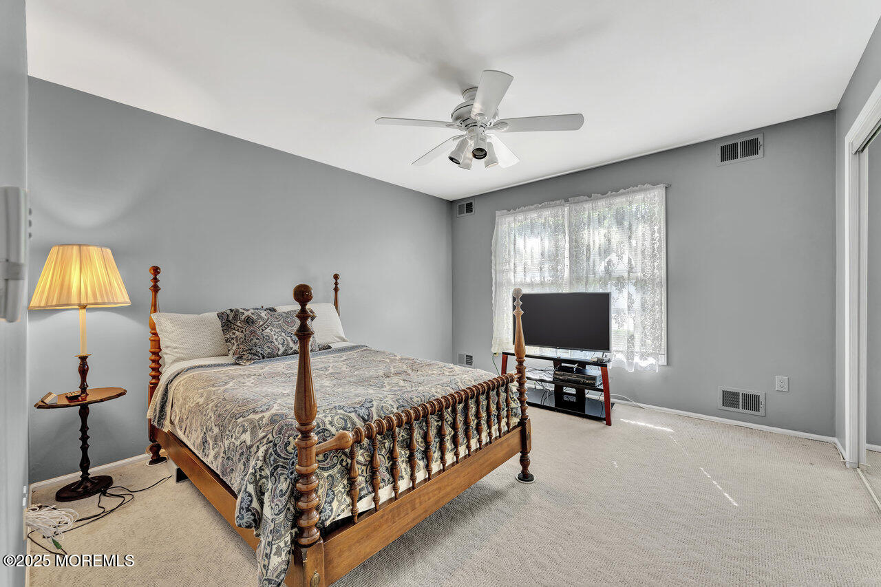 72 Jean Street Lakewood, NJ 08701 - Photo 29 of 34 a bedroom with a bed and a chandelier