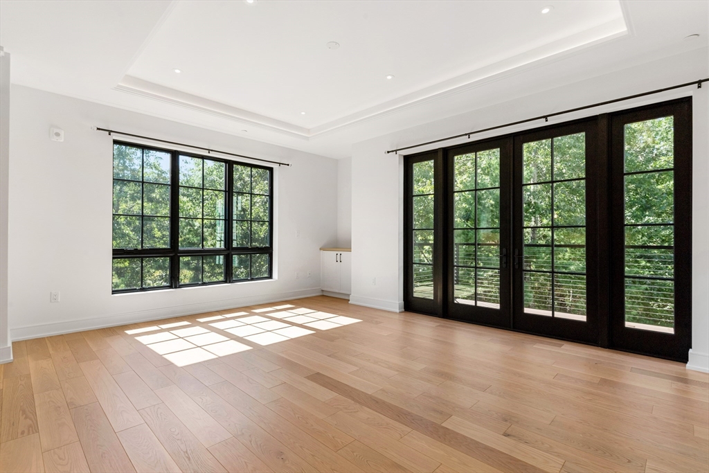148 Weston Road, Unit 207 Wellesley, MA 02482 - Photo 11 of 25 a view of an empty room with wooden floor and a window