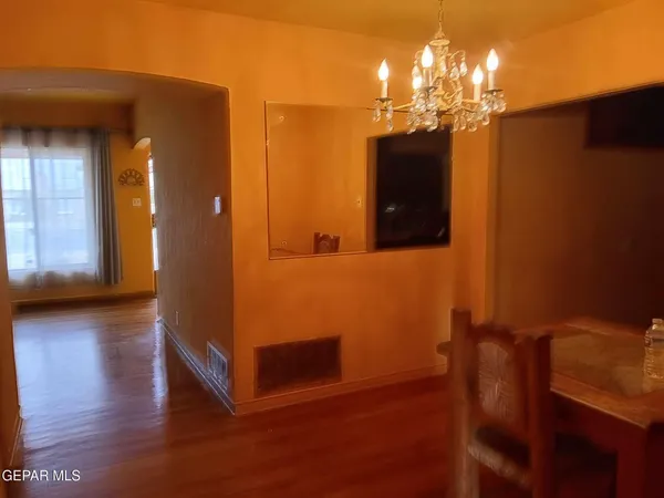 a view of a room with wooden floor and chandelier