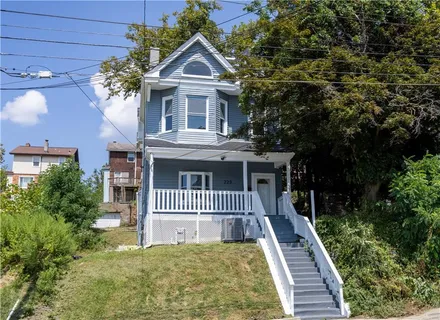 a front view of a house with a garden