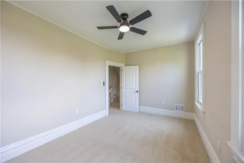 a spacious bathroom with a granite countertop sink a toilet a mirror and shower