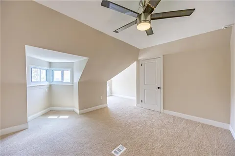 an empty room with a ceiling fan and a window