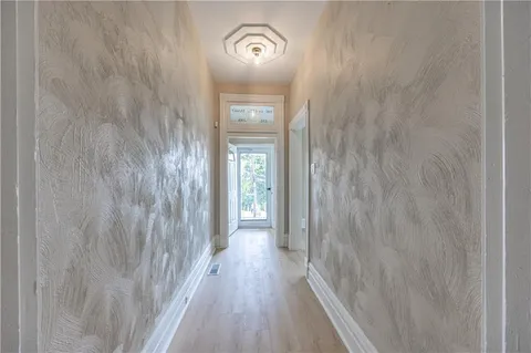 a view of a hallway with wooden floor