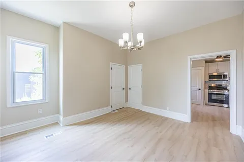 a view of empty room with wooden floor and window