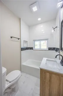 a bathroom with a sink a toilet and bathtub